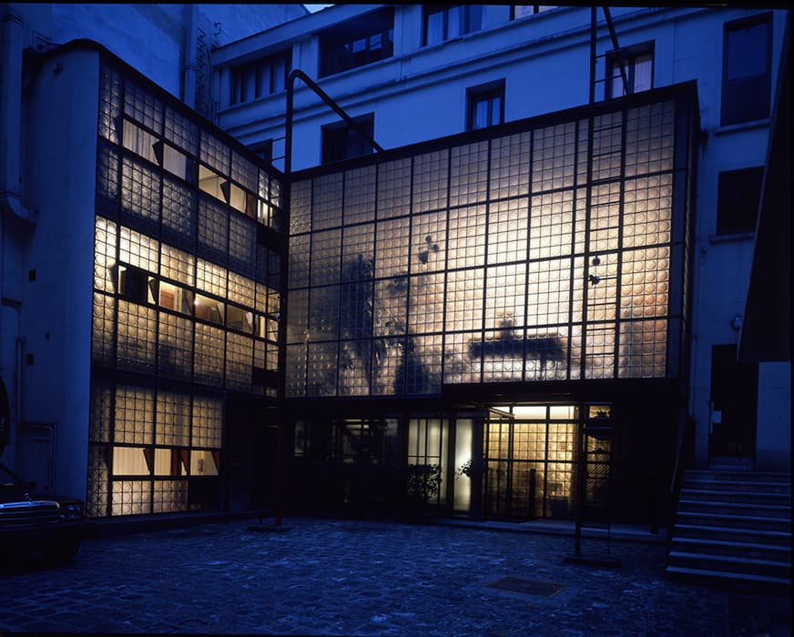 The facade of Pierre Chareau and Bernard Bijvoet’s Maison de Verre at night. Photograph © Yukio Futagawa / GA Photographers