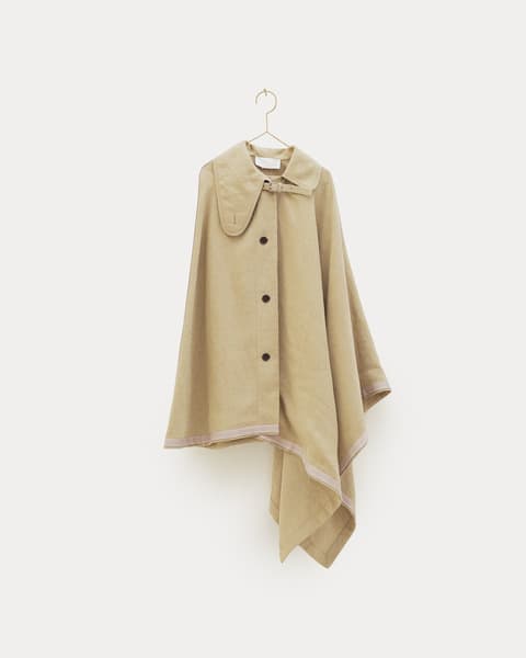 Beige cape with wide collar, button front, and asymmetrical hem, displayed on a hanger against a white background.