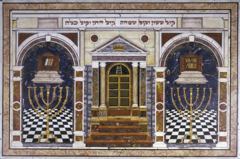 Decorative architectural panel featuring three archways with black and white checkered floors. The central arch shows a golden door with steps leading up, while the left and right arches each display an ornate menorah and an open book on a lectern. The arches are framed by marble columns and intricate stonework. Hebrew text appears at the top.