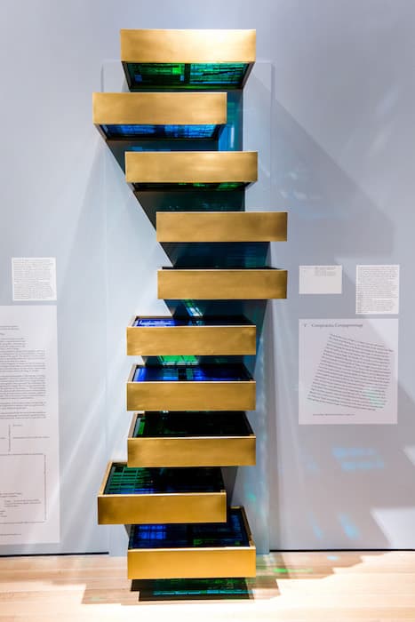 V CONSPIRACIES, COMPAGNONNAGE 

Voluspa Jarpa, What You See Is What It Is, 2013
Steel modules and laser-cut acrylic plates
Courtesy of Mor Charpentier, Paris, Enrique Jocelyn Holt Collection, and the artist

During the early years of the Cold War (1950s–1970s), art in the United States increasingly avoided overt political or social references, instead drawing the viewer’s attention to materials, colors, brushwork, and other purely visual elements. This trend culminated in Minimalist works such as Donald Judd’s iconic stacked boxes of the mid-1960s. Minimalism was given a concise motto by the painter Frank Stella: “What you see is what you see.”

At the time, in Voluspa Jarpa’s homeland, Chile, a military dictatorship supported by the United States executed, tortured, and imprisoned thousands of citizens. Facing a political climate hostile to free expression, many artists couched their political critiques in indirect terms.

Jarpa refers to this history, adulterating Judd’s icon with reproductions of declassified government intelligence documents. The records are so riddled with expurgations that they are nearly as inscrutable as the steel boxes that hold them.

Nineteenth-century Paris saw repeated cycles of unrest and revolution, largely driven by an aggrieved proletariat responding to an entrenched aristocracy and a growing middle class. Compagnonnage, the ancient term for apprenticeship in medieval guilds, was still in operation and became a unifying mechanism of political action.