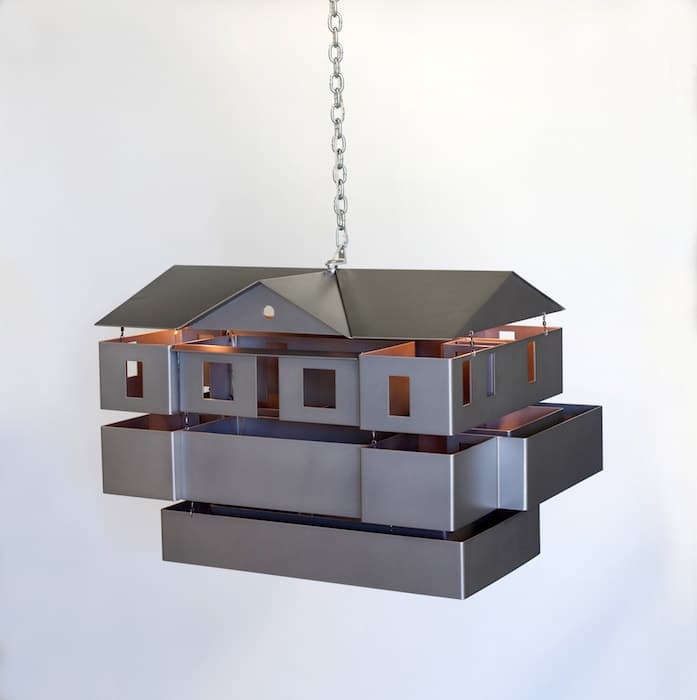 K DREAM CITY AND DREAM HOUSE, DREAMS OF THE FUTURE, ANTHROPOLOGICAL NIHILISM, JUNG

Mike Kelley, Mobile Homestead Swag Lamp, 2010–13
Aluminum, steel, lighting fixtures, wiring
Mike Kelley Foundation for the Arts and Museum of Contemporary Art, Detroit

In The Arcades Project Walter Benjamin challenges the notion that the past is a fixed object, waiting to be elucidated. He calls the present “a waking world, a world to which that dream we name the past refers.” The dream quality of the past suggests that it is mutable, a patchwork of images and symbols that can be understood in myriad ways.

Mike Kelley’s work has also focused on the unreliability of memory. His project Mobile Homestead, a full-scale reproduction of his suburban childhood home, resides on the grounds of the Museum of Contemporary Art in Detroit. The building’s first floor maintains the floor plan of the original; its multilevel basement, closed to the public, includes crawl spaces and rooms that can only be accessed through ceiling hatches. The dreamlike, labyrinthine architecture suggests the slipperiness of the past. Kelley explores the denial of uncomfortable realities of abuse and oppression in domestic life, not in tune with the American Dream as represented by the suburban home, with its white picket fence. This lamp, a miniaturized version of the building, adds another layer of surrealness to the house.