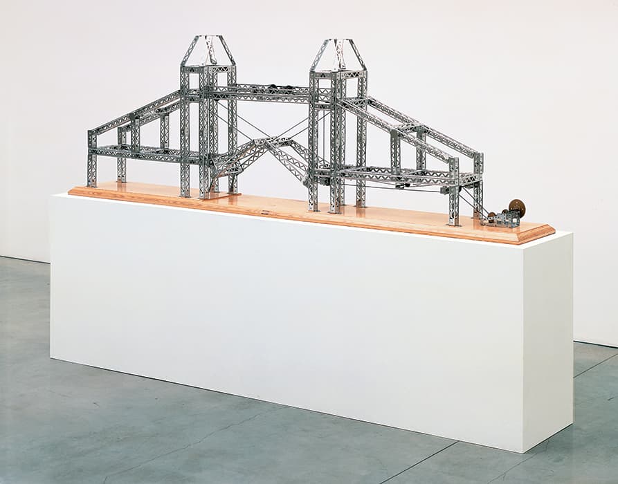 F IRON CONSTRUCTION 

Chris Burden, Tower of London Bridge, 2003
Stainless-steel Mysto Type I Erector parts, gearbox, wood base
Courtesy of The Chris Burden Estate and Gagosian

Innovations in the production of iron in the eighteenth century helped to bring about the Industrial Revolution. Cast iron was light and strong; its use in bridges, buildings, and machines altered architecture and engineering, making cities taller and architecture airier—as exemplified by the Eiffel Tower, built in 1889, and glass-vaulted arcades. Walter Benjamin suggests in Convolute F that iron construction represented a turn in the history of architecture in which the technical properties of a material began to dictate the styles of buildings, rather than the reverse. Chris Burden’s bridges evoke the giddy sense of possibility in the early days of iron construction. He uses children’s building sets to represent real and imagined architecture, often at a scale that children can only dream of.