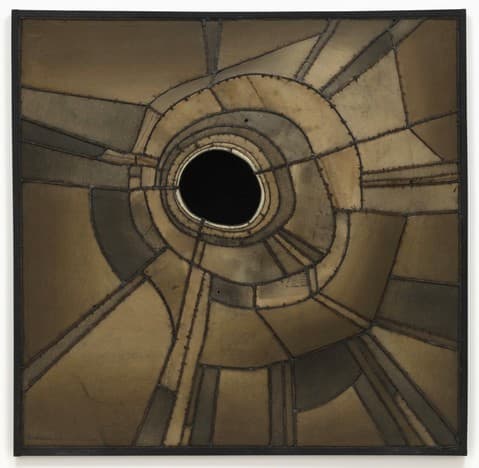 Abstract circular composition with stitched and textured brown, tan, and black fabric segments radiating from a central black void. The artwork features visible seams, curved and angular panels, and a sense of depth as the shapes converge into the dark central circle. Framed in black.
